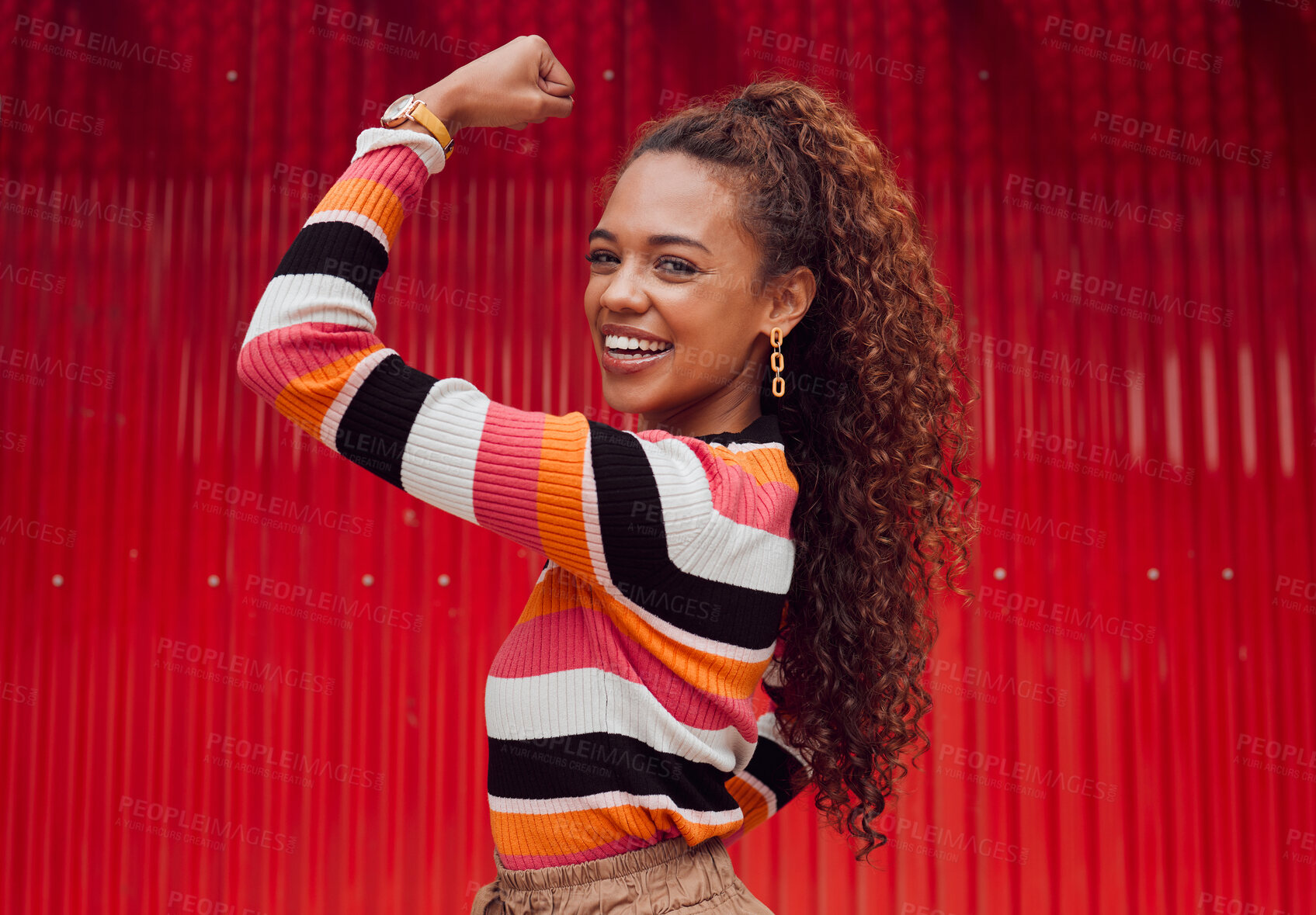 Buy stock photo Beauty, fashion and strong with a black woman flexing her bicep outdoor on a red background with a smile. Empowerment, proud and strength with an attractive young female showing her arm muscle