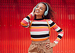 Music headphone streaming, happy and fashion black woman smile outdoor in Brazil. Happiness of a girl feeling relax freedom and cheerful mindset listening to audio and song track with red background