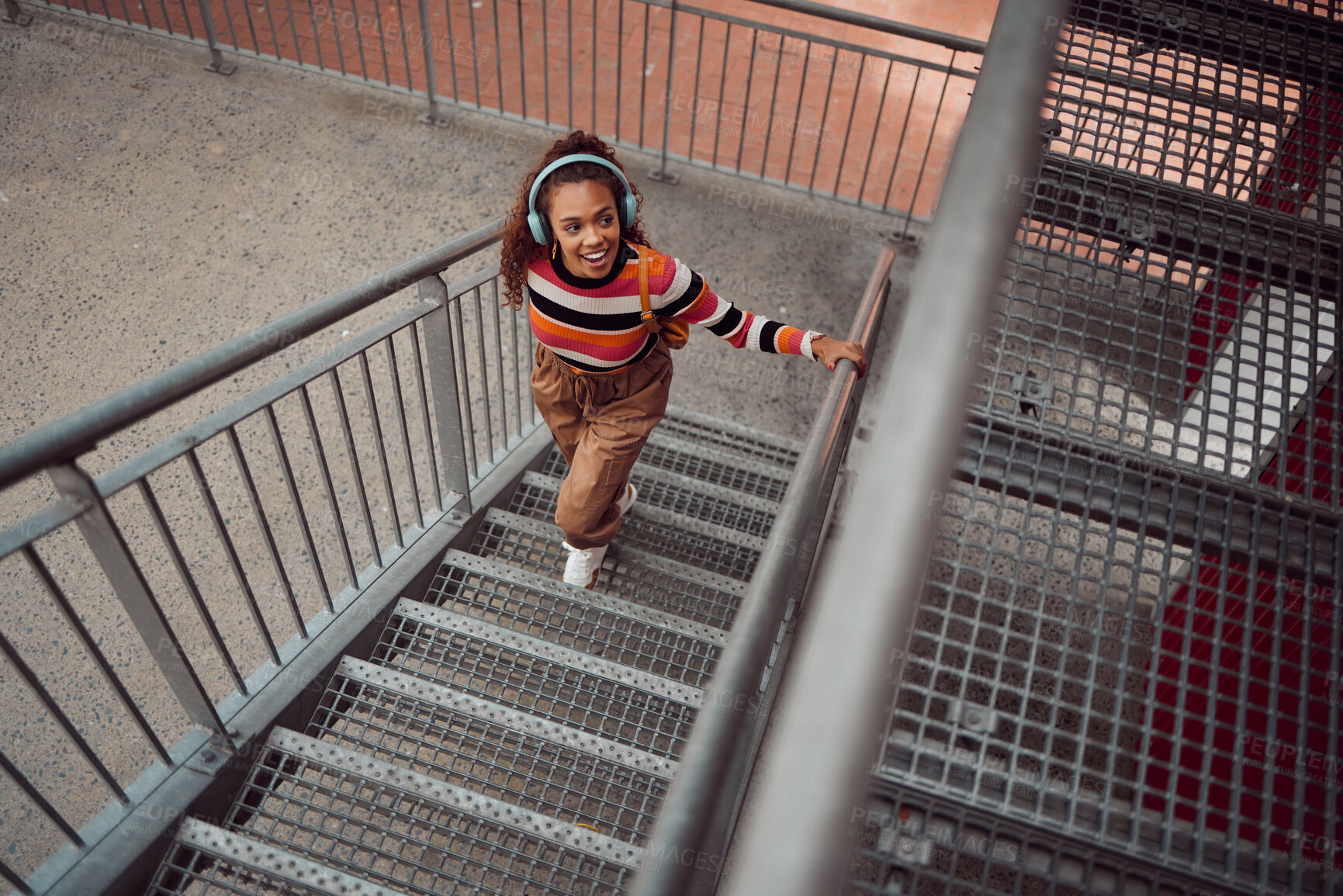 Buy stock photo Explore, city and woman on stairs with headphones listening to music, travel and weekend lifestyle. Fashion, beauty and young girl taking walk, adventure and freedom exploring urban town