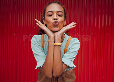 Buy stock photo Fashion, kiss and black woman being playful against a red wall in the city of Norway for travel. Face of a young, happy and pouting girl with luxury makeup, clothes and happiness on an urban holiday