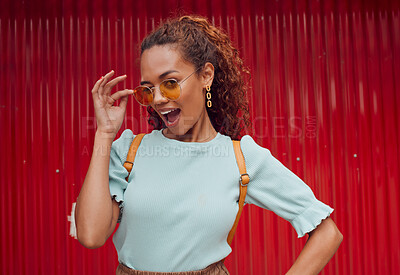 Buy stock photo Trendy, fashion of black woman cool sunglasses with a playful attitude on red background outside. Happy girl model with comic expression and positive energy or attitude on tourism trip in Sao Paulo