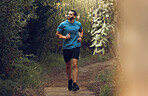 Running, fitness man and forest run on a trail for exercise, workout and training in nature for health and wellness. Athlete man out jogging or active in the woods with trees and fresh air for cardio