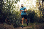 Fit man, nature run in forest and running for cardiovascular health or body wellness past green trees. Sports runner, cardio fitness training and working out doing  offroad marathon workout exercise 