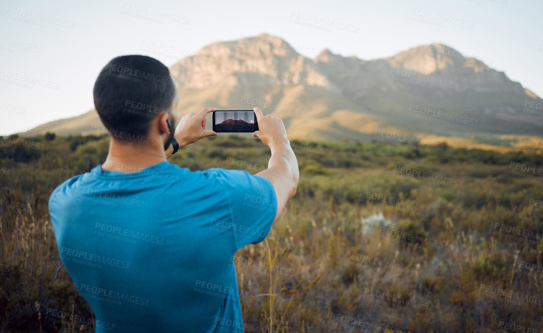 Buy stock photo Smartphone photography, mountain and hiking man in nature for outdoor adventure, social media location update or gallery memory. Young influencer taking landscape picture with cellphone for trekking