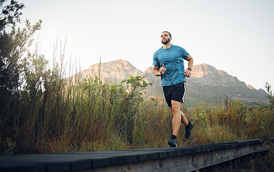 Buy stock photo Runner, fitness and man in nature running for outdoor workout, healthy energy and wellness goal with sky mock up background. Sports person with exercise training motivation jogging near the mountains