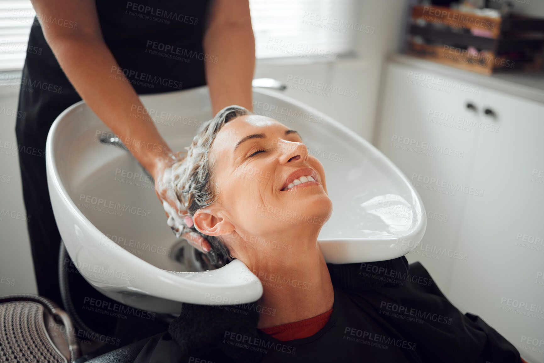 Buy stock photo Hair, smile and wash, woman in salon relax with head back and hairdresser cleaning with shampoo and conditioner. Beauty, hair care and a luxury massage for client with professional stylist in spa.