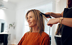 Hairdresser, flat iron and woman in salon for hair appointment, looking in mirror. Stylist using hair straightener on client in beauty salon or hair salon for straight hair, heat treatment and style