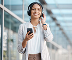 Professional woman on break, smartphone with headphones listening to radio, music or podcast in cityscape. Young, business person and streaming online service, audiobook and subscription playlist. 