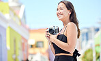 Photography, summer and happy photographer with camera shooting pictures of colorful houses in the city. Smile, woman and creative freelancer takes a photo of Cape Town on a holiday vacation outdoors