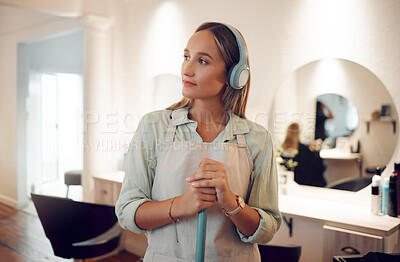 Buy stock photo Cleaning, sweeping and salon with a woman cleaner listening to music while working with a broom. Idea, headphones and streaming audio with a female at work in a hairdresser for hygiene or cleanliness