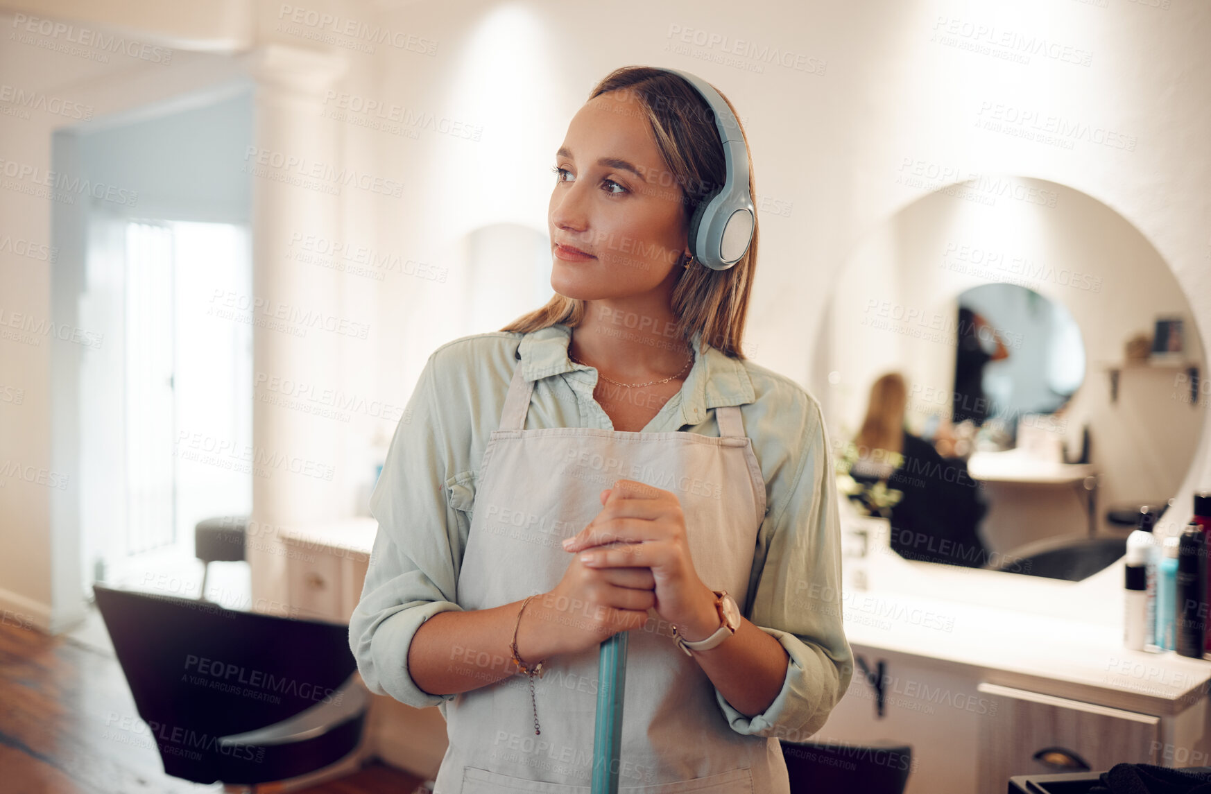 Buy stock photo Cleaning, sweeping and salon with a woman cleaner listening to music while working with a broom. Idea, headphones and streaming audio with a female at work in a hairdresser for hygiene or cleanliness