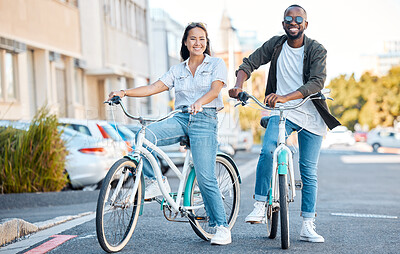 Buy stock photo Bike, couple and travel with a black man and asian woman cycling in the city for sightseeing or adventure. Bicycle, carbon footprint and love with a male and female dating in an urban town together