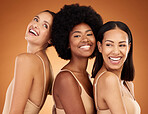 Beauty, diversity and skincare with woman friends in studio on an orange or brown background. Happy, natural and real with a different female group posing together for wellness or skin health