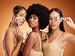 Makeup, beauty and women with brush for cosmetics against a brown mockup studio background. Portrait of young model group with cosmetic facial foundation and a luxury product for skin wellness
