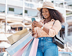 Black woman, retail shopping bag and city smartphone search fashion sales, social media and online newsletter, discount code and store promotions. Wealthy customer using phone on ecommerce mobile app