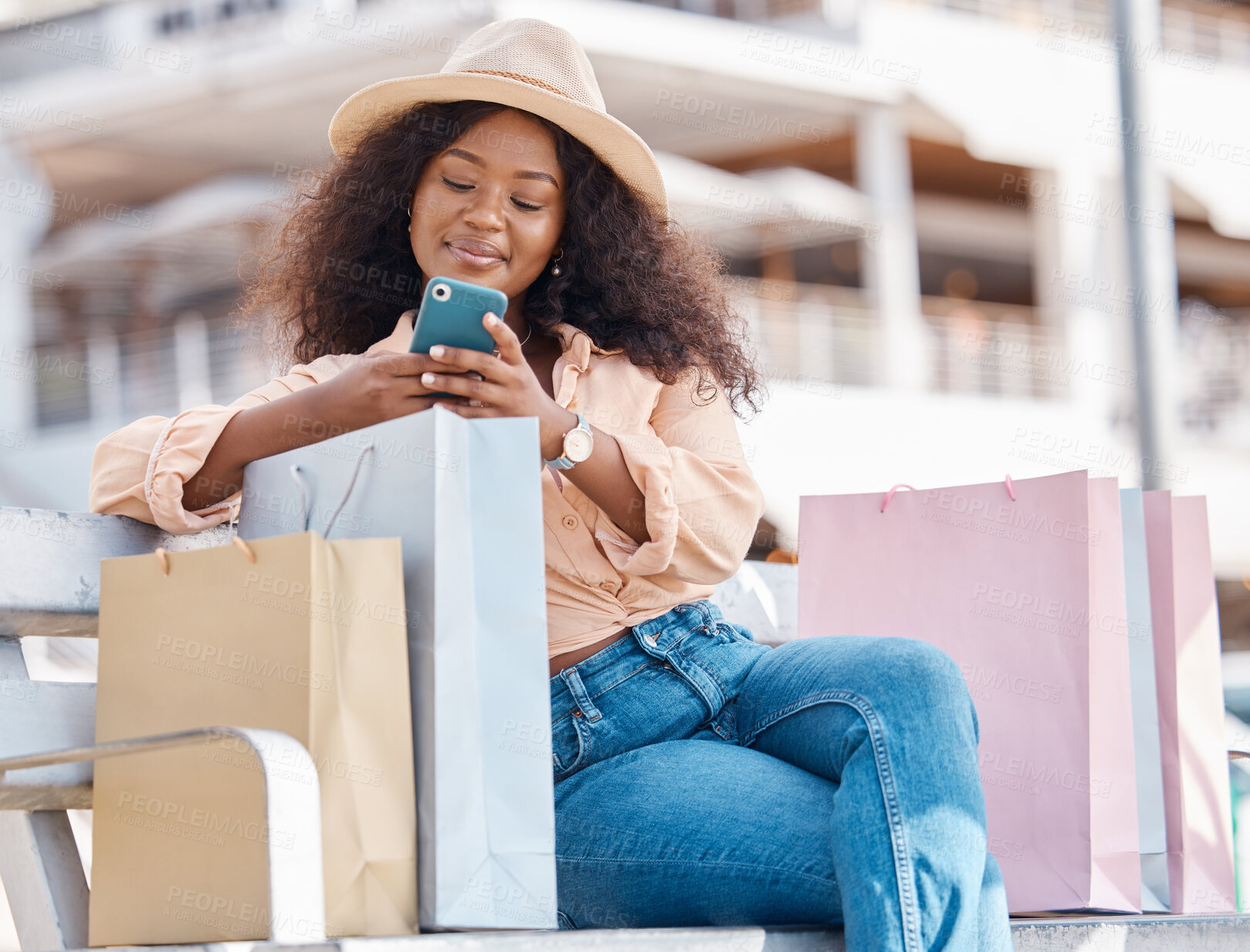 Buy stock photo Phone, shopping and happy black woman with shop and store bags on a bench outdoor. Online, mobile and ecommerce app scroll of a young person smile from Miami with technology and retail paper bag