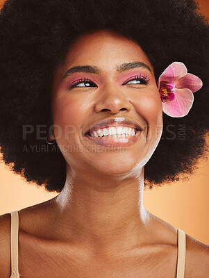 Buy stock photo Beauty, skincare and black woman with flower in afro hair with pink makeup, cosmetics and smile, excited about natural treatment. Face of african female model with orchid against orange background
