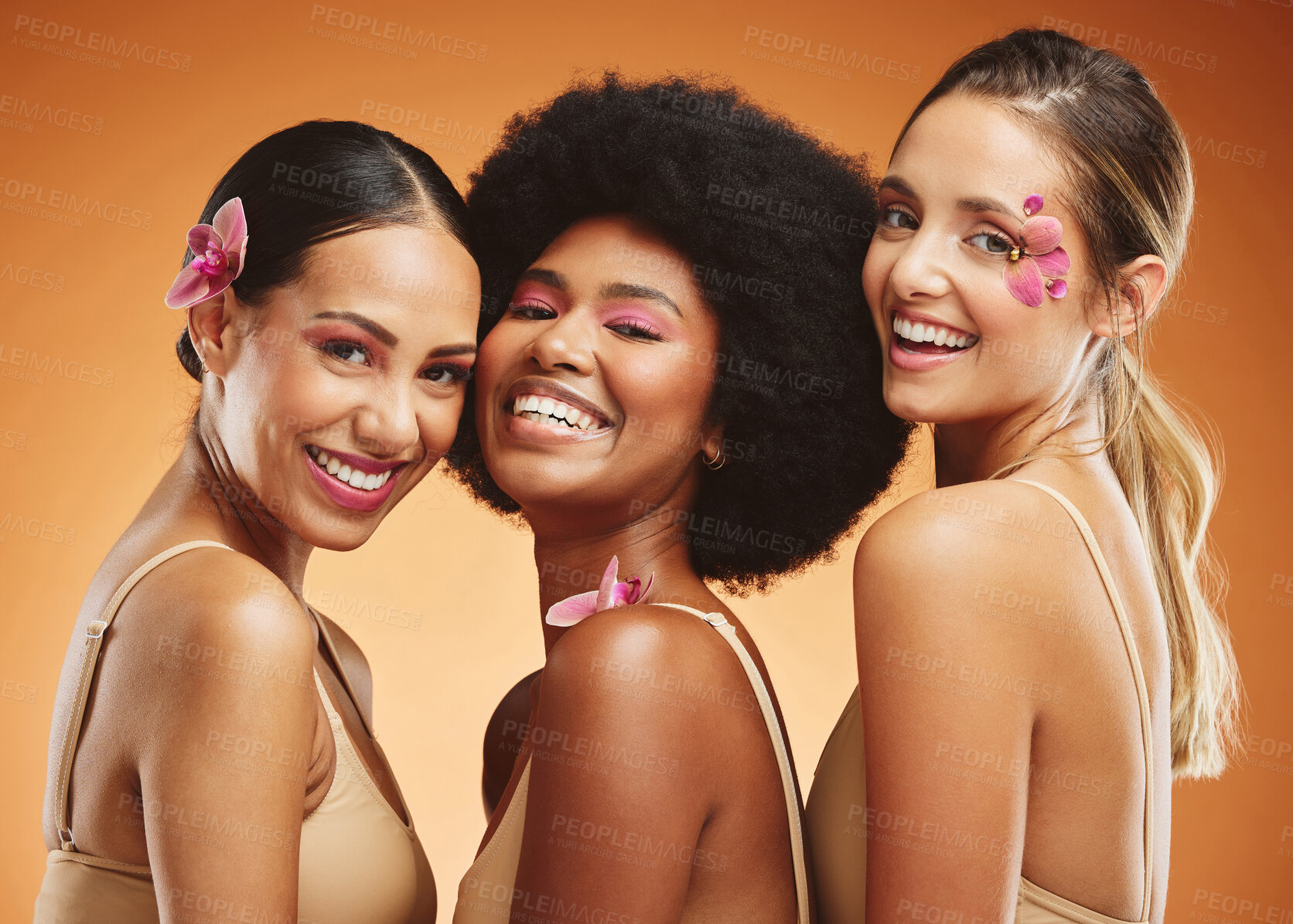 Buy stock photo Beauty, diversity and smile with women and flowers for makeup, cosmetics and wellness. Tropical, natural and luxury with model in brown background for summer, creative and spa skincare treatment