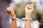 Activist woman hands fist, handcuffs and social justice protest of women protesting outdoor. Hand view of empowerment, black lives matter or iran sexual assault fight for human rights with power
