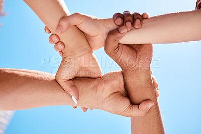 Buy stock photo Wrist hands, team and community support diversity people, protest group and human rights freedom on blue sky background. Below solidarity, partnership and motivation of goals, trust and world justice