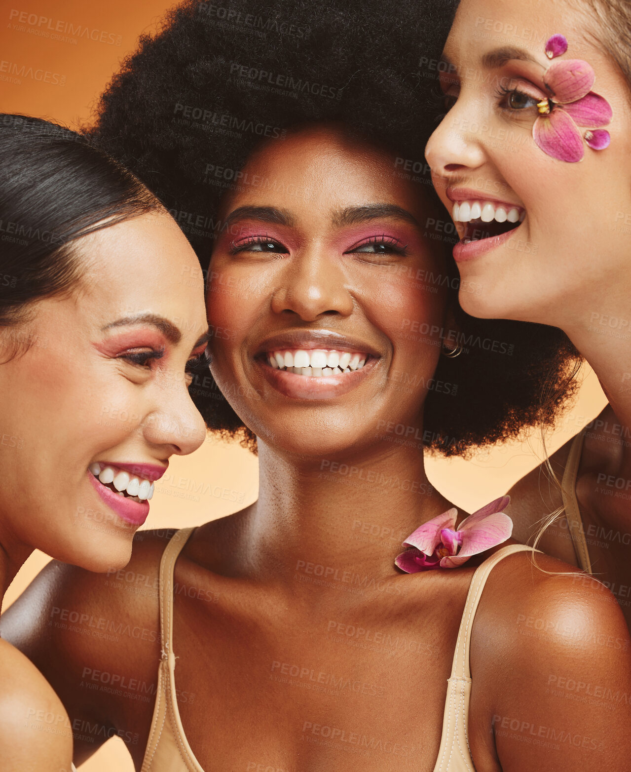 Buy stock photo Women, beauty and flowers, makeup and diversity of models on orange studio background. Skincare, face and happy, young and elegant female group posing together with cosmetics, orchids or pink plants.