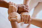 Hands, together and solidarity with a group of people strong in unity from above for teamwork or collaboration. Trust, support and community with a team or partnership holding a wrist for motivation