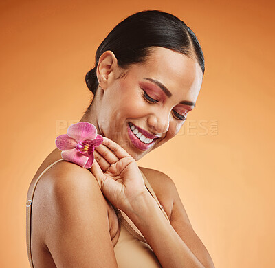 Buy stock photo Flower, skincare and woman with smile for beauty against an orange mockup studio background. Happy, young and thinking model with an orchid plant for cosmetics, skin wellness and natural health