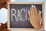 Racism, protest and stop hands on blackboard to remove inequality writing for a change in society. Race, prejudice and black lives matter group cleaning chalkboard to erase word of hate closeup.