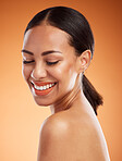 Woman, happy and beauty for skincare, health and wellness with cosmetic, glow and shine on face. Model, smile and healthy for makeup, cosmetics and dermatology on skin with orange studio background