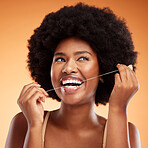 Flossing, dental and black woman cleaning teeth against an orange studio background. Young, African and thinking model with idea while getting results from care and wellness of mouth and tooth health