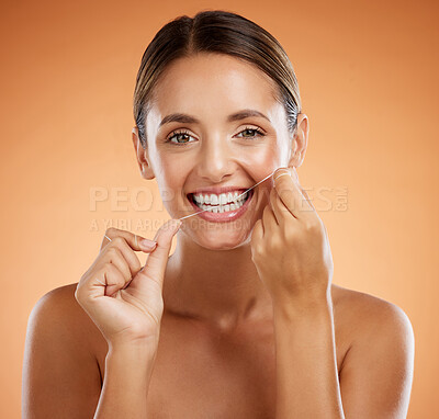 Woman, dental flossing and teeth with smile for clean hygiene and health against a studio background. Portrait of a happy toothy woman smiling in beauty floss for hygienic mouth, oral and gum care