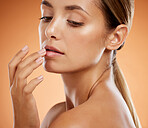 Woman, lips and beauty for cosmetics, makeup and hand for treatment against a studio background. Closeup of beautiful female model in mouth, oral and luxury cosmetic skincare for lipstick glow