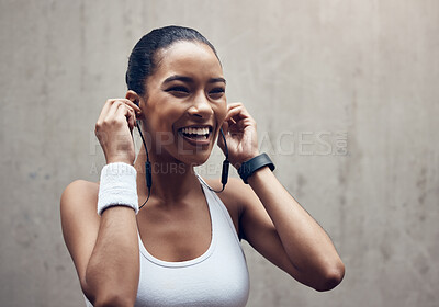 Buy stock photo Music, fitness and exercise with a sports woman streaming audio during training or a workout on a gray background. Health, cardio and training with a female runner listening on earphones during a run