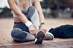 Workout, fitness and woman tying shoes on feet, sitting on ground before marathon training or running. Health, wellness and sports footwear, motivation for exercise for girl athlete or track runner.