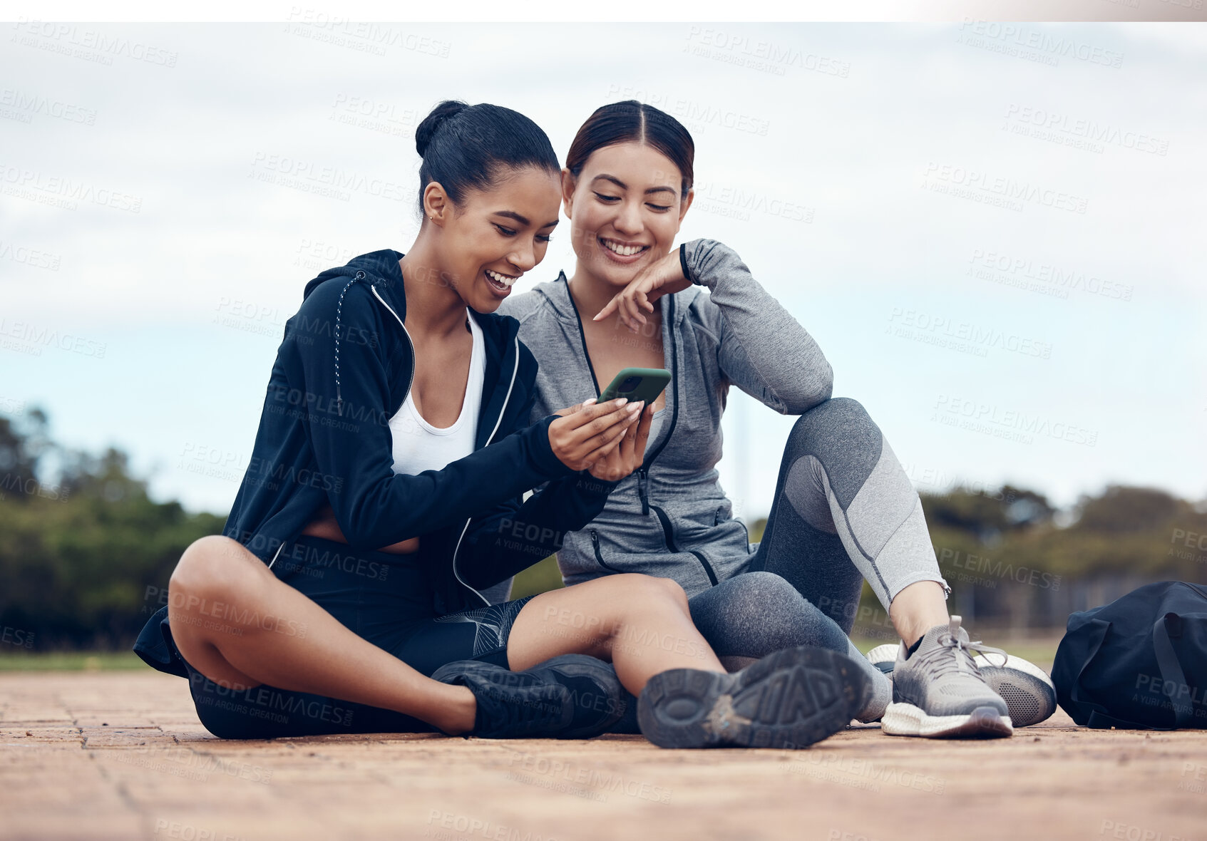 Buy stock photo Relax, phone and fitness friends on social media app for chill break together after training. Happy girl friendship internet news, funny meme post and internet entertainment for workout rest outdoor