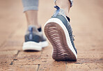 Runner, shoes and outdoor walk of a woman feet before fitness, workout and running exercise. Sport training, walking and healthy cardio of a person on a brick pavement ready for a sports run