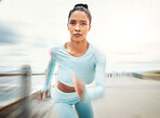 Woman, running and exercise motion blur by ocean, sea or promenade for health, fitness and wellness. Sports, runner and female from India out for run, training or cardio workout outdoors by seashore

