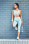Fitness, fit and exercise with woman out for a run, running and cardio workout in city against brick wall. Health, wellness and athlete female ready for sports training with water bottle for running