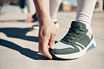 Shoes, hand and stretching with a sports man touching his toes during an exercise or fitness warmup in the city. Health, training and workout with a male athlete getting ready for competition closeup