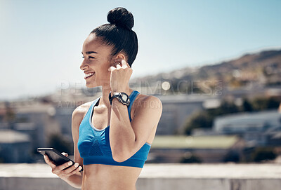Buy stock photo Fitness, music and woman athlete on a phone on rooftop for sports workout or exercise in city. Training, smile and happy girl from Mexico networking on social media with smartphone on balcony in town