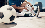 Football, fitness or man with leg injury while training, exercise or soccer workout on roof of building outdoor. Wellness, health or soccer player with muscle pain, bone emergency or sports accident
