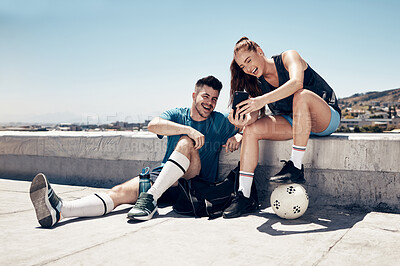 Buy stock photo Soccer training, phone and friends happy on video call or laugh at social media outdoors. Fitness man, athlete woman and relax after lifestyle workout chat on tech communication in city