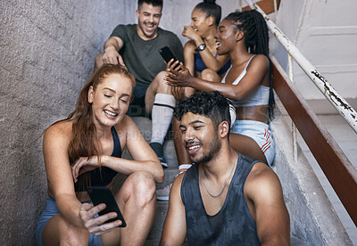 Buy stock photo Fitness, phone and group of friends on stairs networking on social media together after gym workout. Happy, smile and sports people sitting and watching funny comic videos on internet with smartphone