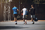 Basketball court, men and friends walking in sports ground for athlete game training and workout. Black people, basketball and fitness together for team tournament preparation at outdoor court.

