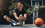 Training, basketball player and man stretching legs in outdoor community court, muscle energy and healthy sports game performance. Happy, strong and young male athlete warm up exercise in competition