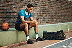 Man, basketball and phone with sports app, communication and social media online outdoor. Sport male in rest after fitness, exercise and game time check, message or text on mobile 5g smartphone