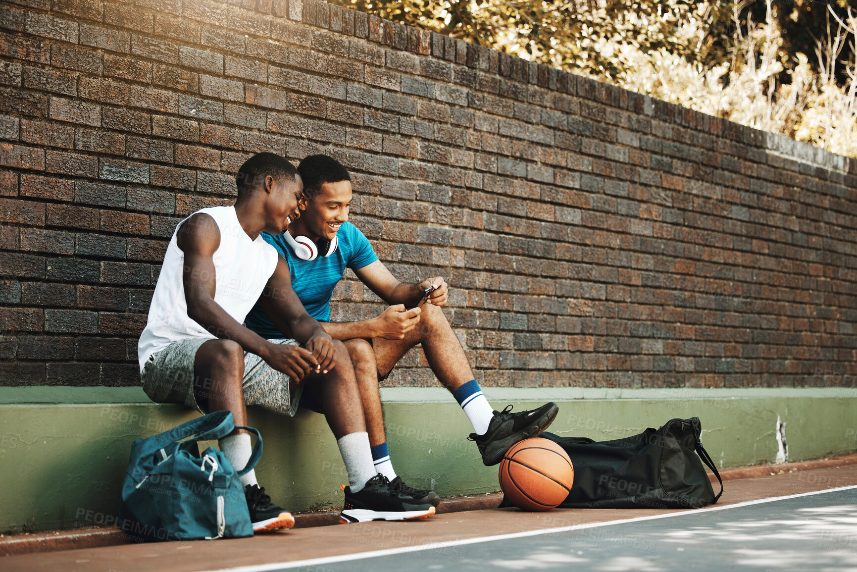 Buy stock photo Friends, phone and break after exercise, workout and basketball game in city with men bonding and laughing. Sports, rest and two guys having fun, enjoying social media comedy, post and online meme