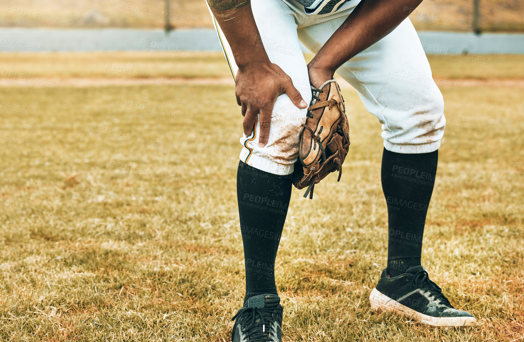 Buy stock photo Man, baseball and sport leg injury suffering in pain, agony and discomfort during training match or game on the field. Male athlete hurt holding painful area in sports accident on grass or pitch