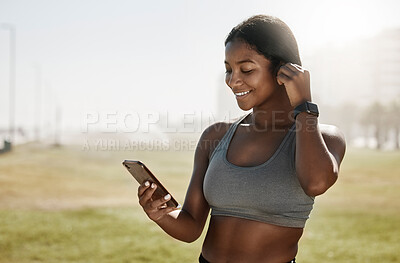 Buy stock photo Black woman, music earphones or phone for fitness podcast, exercise motivation or training radio on sports grass field. Smile, happy and mobile technology for athlete or workout health data on 5g app