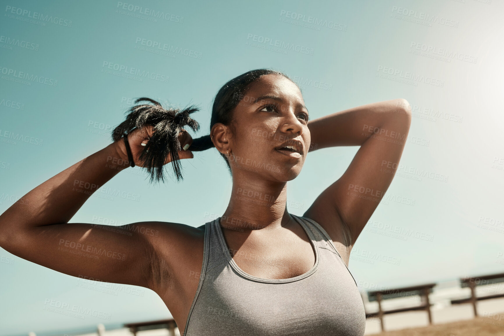 Buy stock photo Woman tying her hair before an outdoor workout for fitness, health and wellness in nature. Training, sports and healthy girl athlete from Mexico preparing for a run or cardio exercise in a field. 